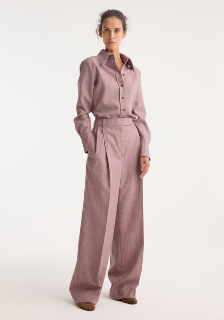 Model wearing a fitted tweed shirt in mauve melange, featuring a sharp collar, button-front, paired with high-waisted trousers; part of Róhe's refined collection.