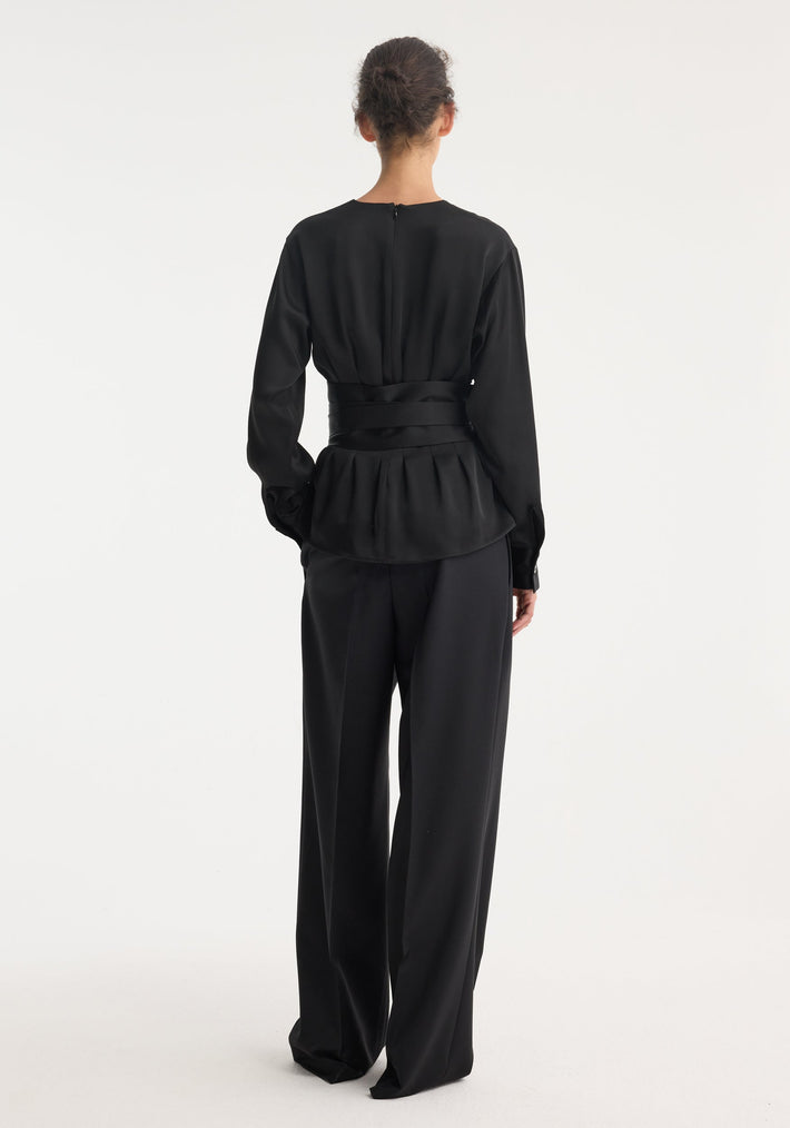Kimono satin top in a minimalist design, with a round neckline, long sleeves, and a wrap waist tie, paired with wide-leg trousers.