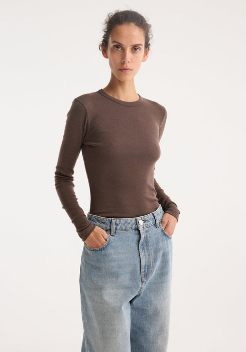 Model wearing the Fine merino long sleeve in brown melange, featuring a crew neck and fitted silhouette, paired with light-blue high-waisted jeans and black loafers.