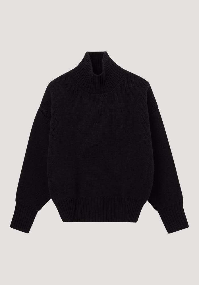 Sculptural compact turtleneck | black: A plain black knit sweater with a high collar, dropped shoulders, long sleeves, and ribbed neck, cuffs, and hem.