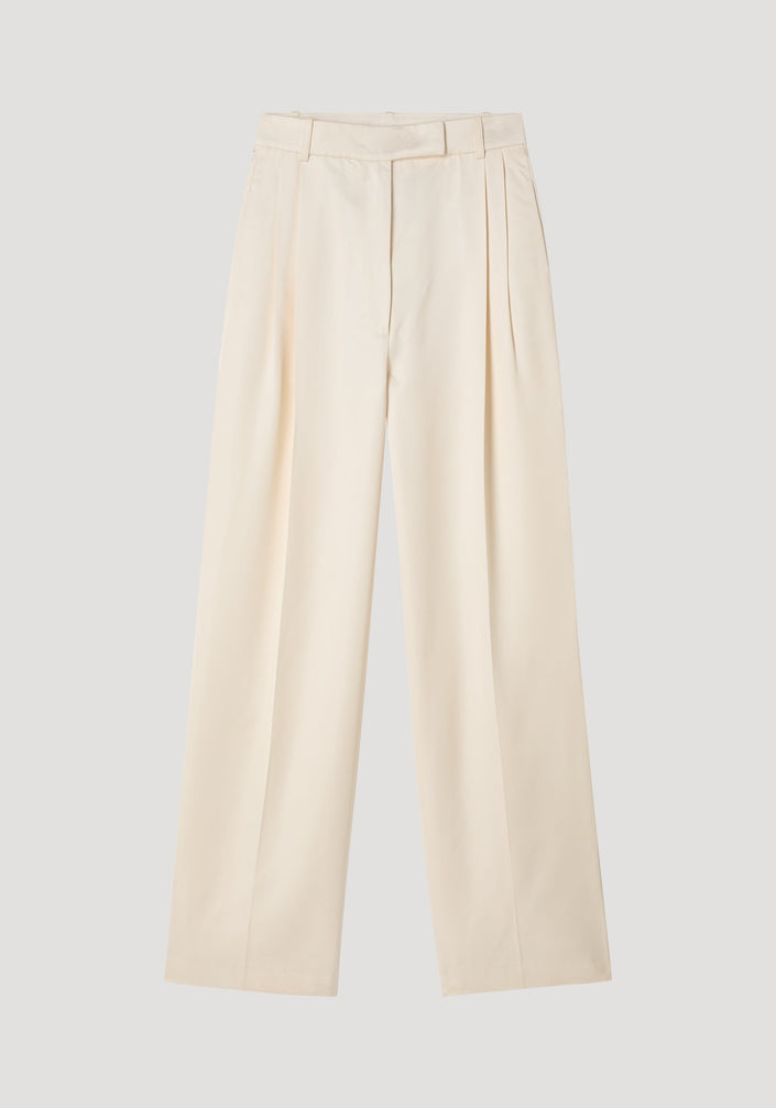 High-waist satin trousers in cream with a tailored waistband, front and back pleats, and welt pockets, laid flat on a neutral background.