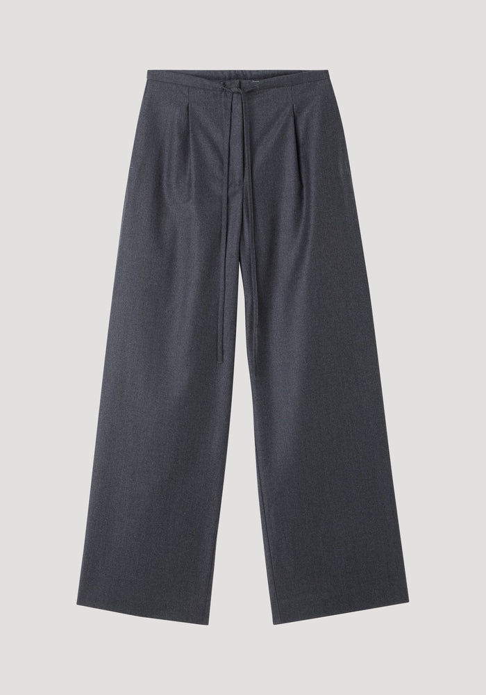 Relaxed soft wool trousers in dark grey melange, featuring wide-leg silhouette, high waist with drawstring, subtle pleats, and slanted pockets, crafted from lightweight virgin wool.