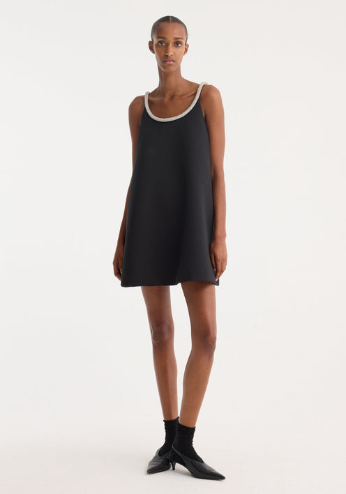 Woman wearing a black sleeveless dress on a white background