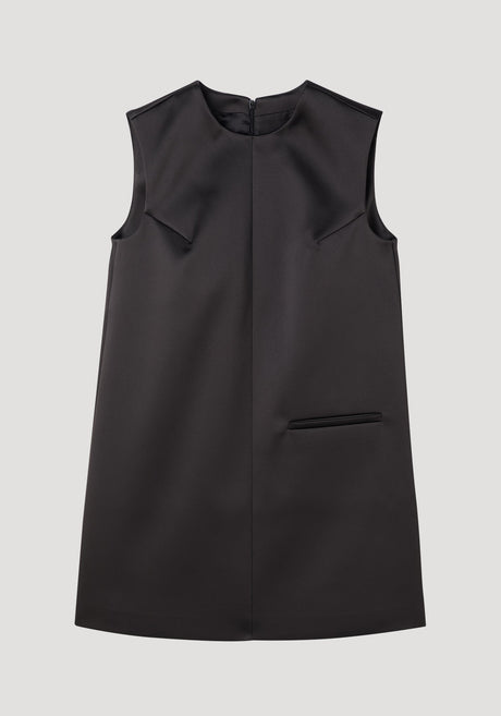 Sculptural cape dress in black, sleeveless A-line with a high neckline, single welt pocket, center-front seam, and dramatic box pleats for a tailored fit.
