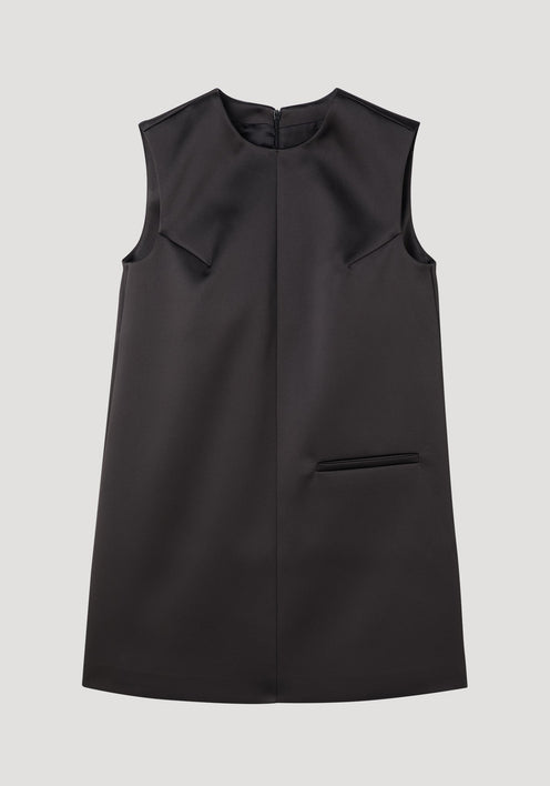 Sculptural cape dress in black, sleeveless A-line with a high neckline, single welt pocket, center-front seam, and dramatic box pleats for a tailored fit.