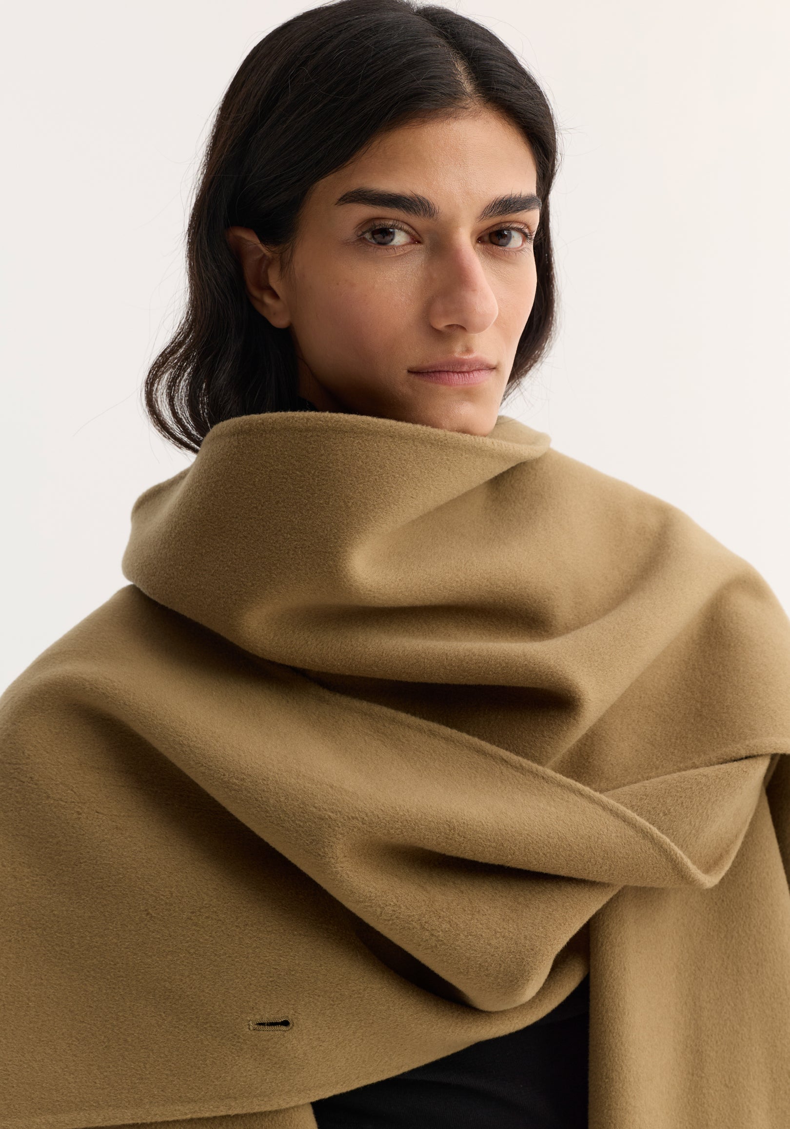 Close-up of a woman wearing a camel-colored Signature double-faced scarf coat | camel, featuring a soft, draped fabric with a cozy, oversized design.