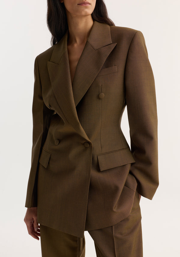 Hourglass blazer in golden brown featuring a double-breasted design, wide peaked lapels, covered buttons, and matching trousers, creating a structured, feminine silhouette.