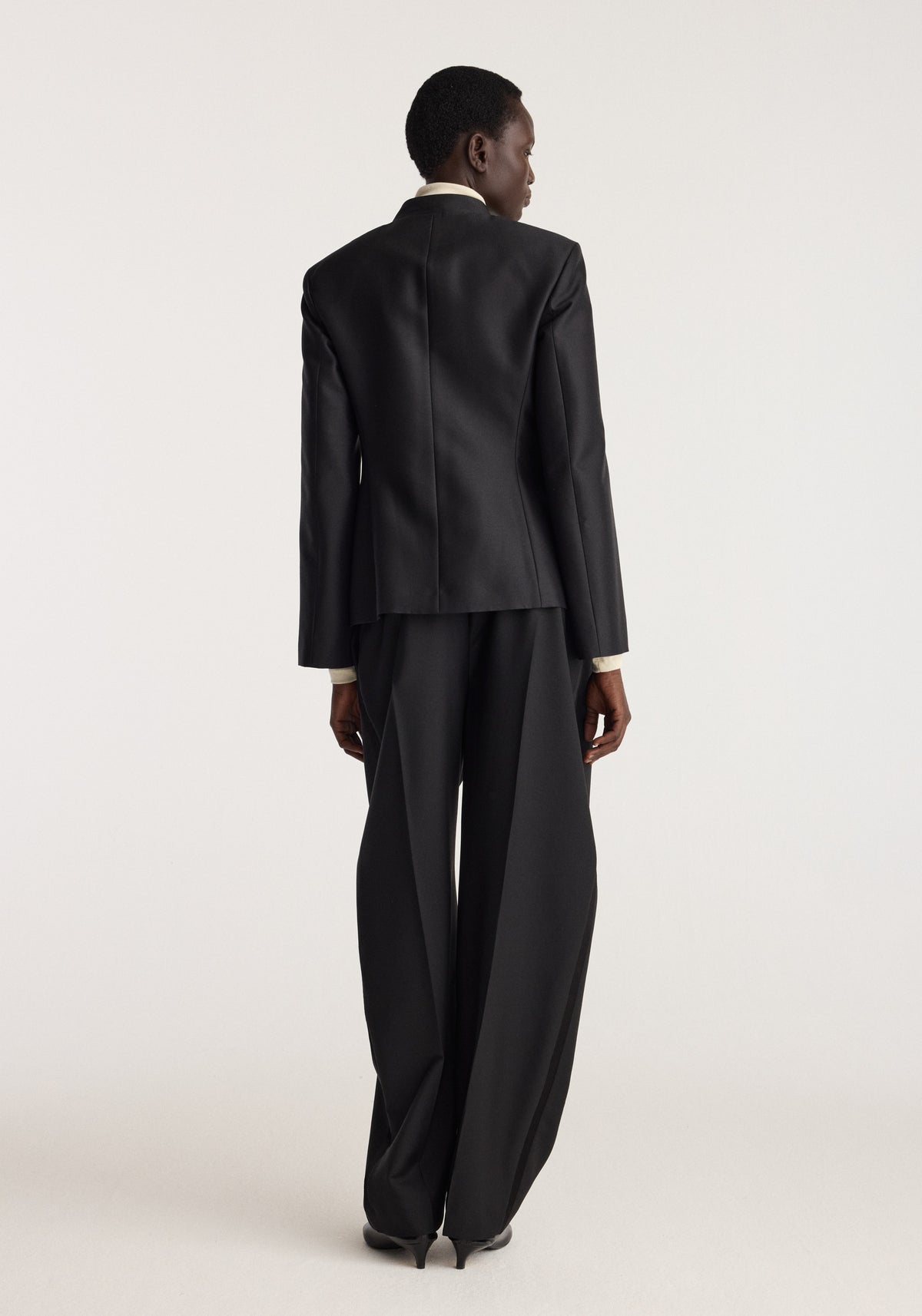Sculptural pankou closure blazer | black seen from the back on a model with a tailored silhouette long sleeves and a sleek black finish