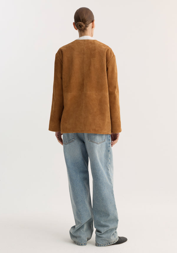 Back view of a person in a Pankou closure suede jacket, featuring pankou knot closures and embroidered edges, paired with wide-leg denim jeans and dark slip-on shoes.