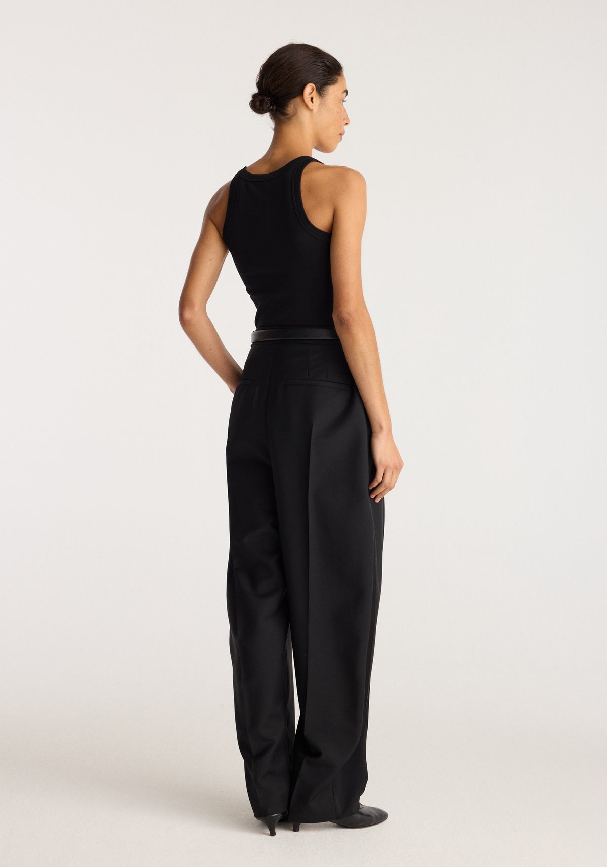 Merino scoop neck top | black shown from the back on a model with a sleeveless silhouette and black wide leg trousers