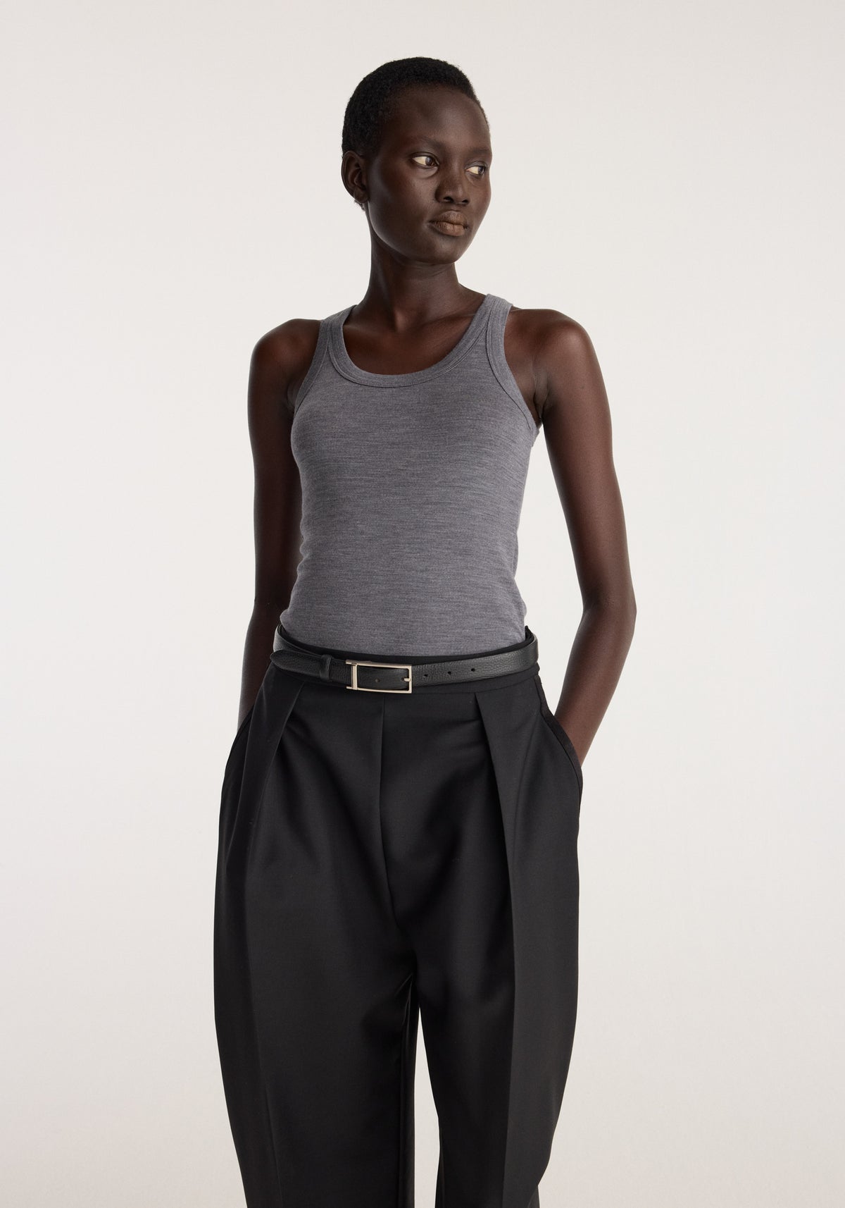 Merino scoop neck top | mid grey melange worn with black trousers by a model in a studio setting
