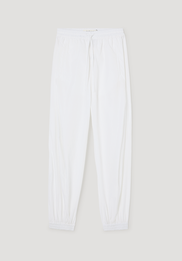 Balloon track pants in optic white with crinkled texture, featuring an elastic waistband, drawstring, welt pockets, and elastic cuffs for a voluminous look.