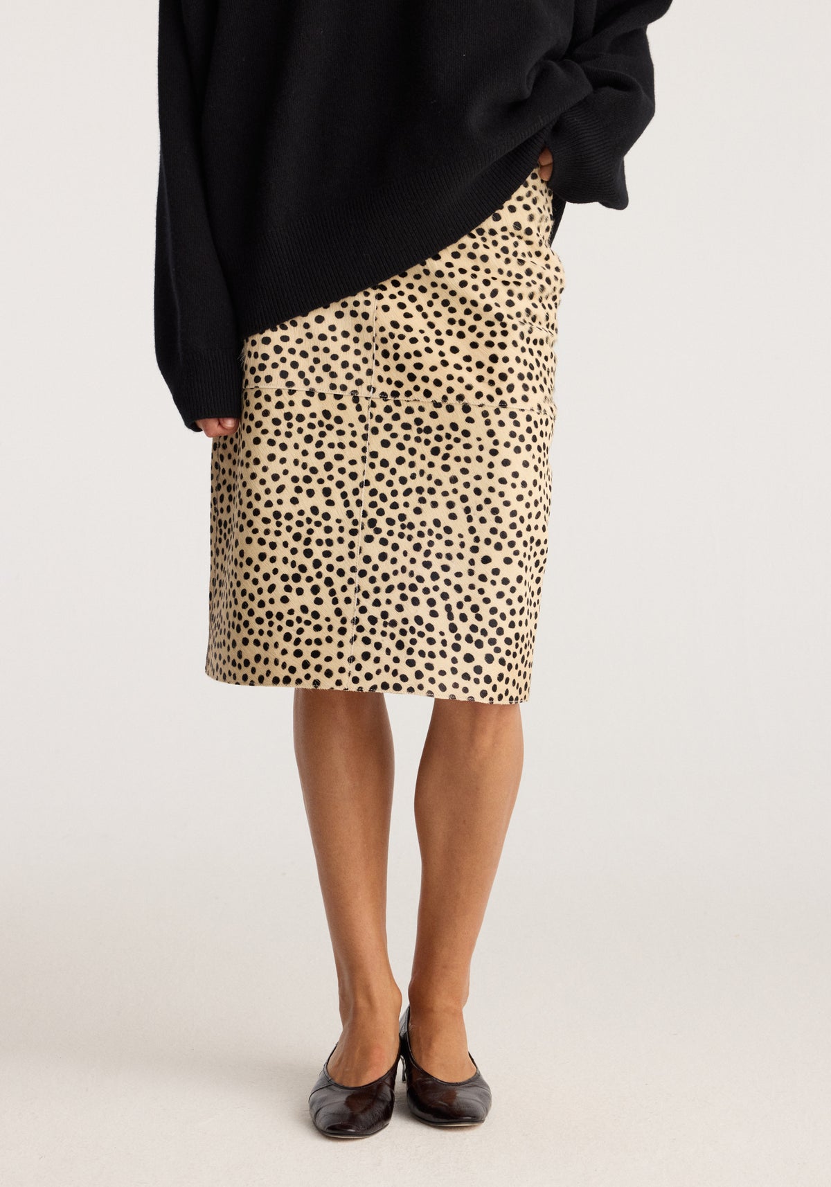 Pony hair pencil skirt | cheetah modeled with a black sweater and black flats showing its knee length and fitted silhouette