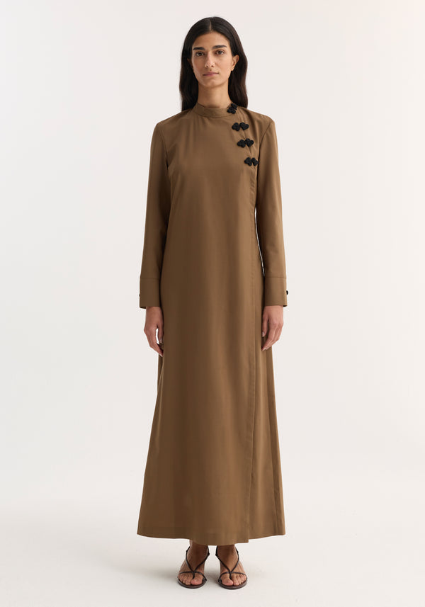 Model wearing Pankou closure dress | mocha, featuring floor-length design, long sleeves, asymmetrical pankou buttons, and side split, paired with black strappy sandals.