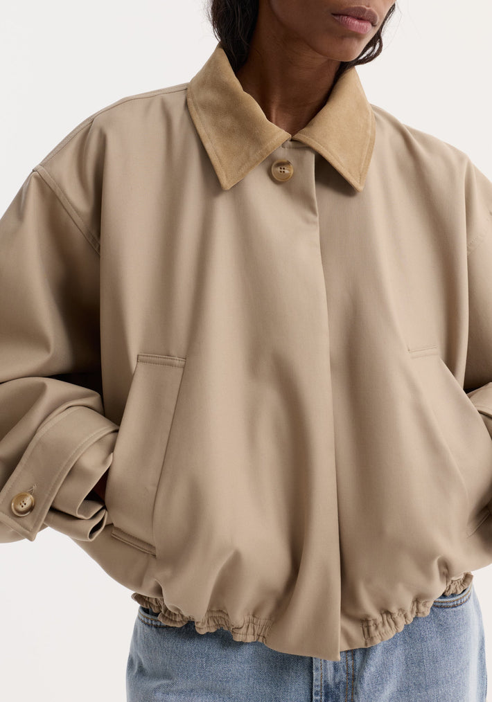 Suede collar blouson jacket in sand, featuring a cropped design with dropped shoulders, wide sleeves, suede-like collar, and elasticized hem, worn with pockets.
