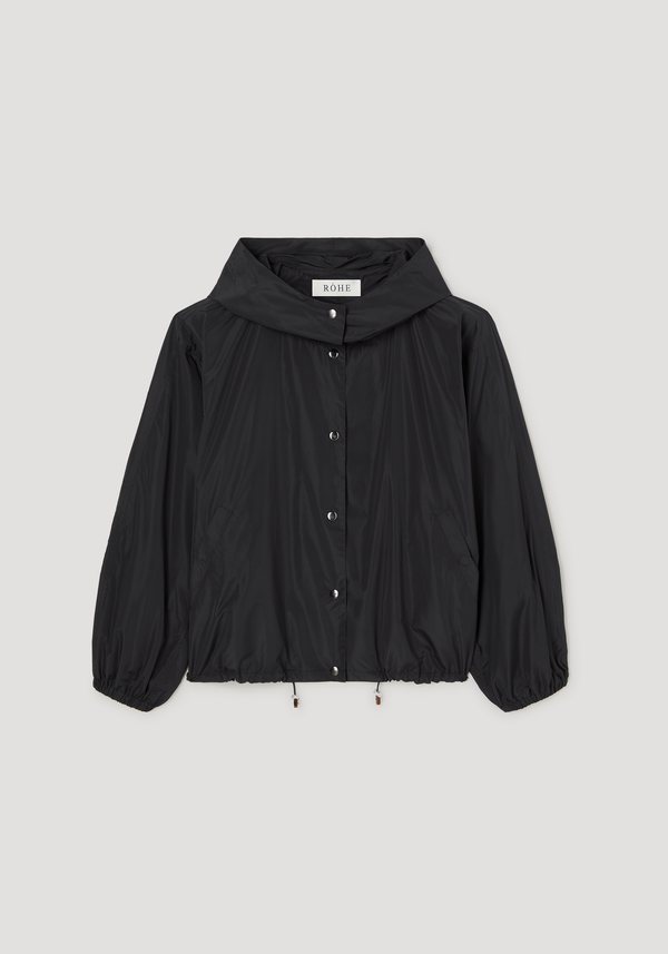 Volume silk-blend jacket | black, featuring a stand-collar hood, snap-button closure, elasticated cuffs, slanted pockets, and adjustable drawcord hem, finishing at the hip.