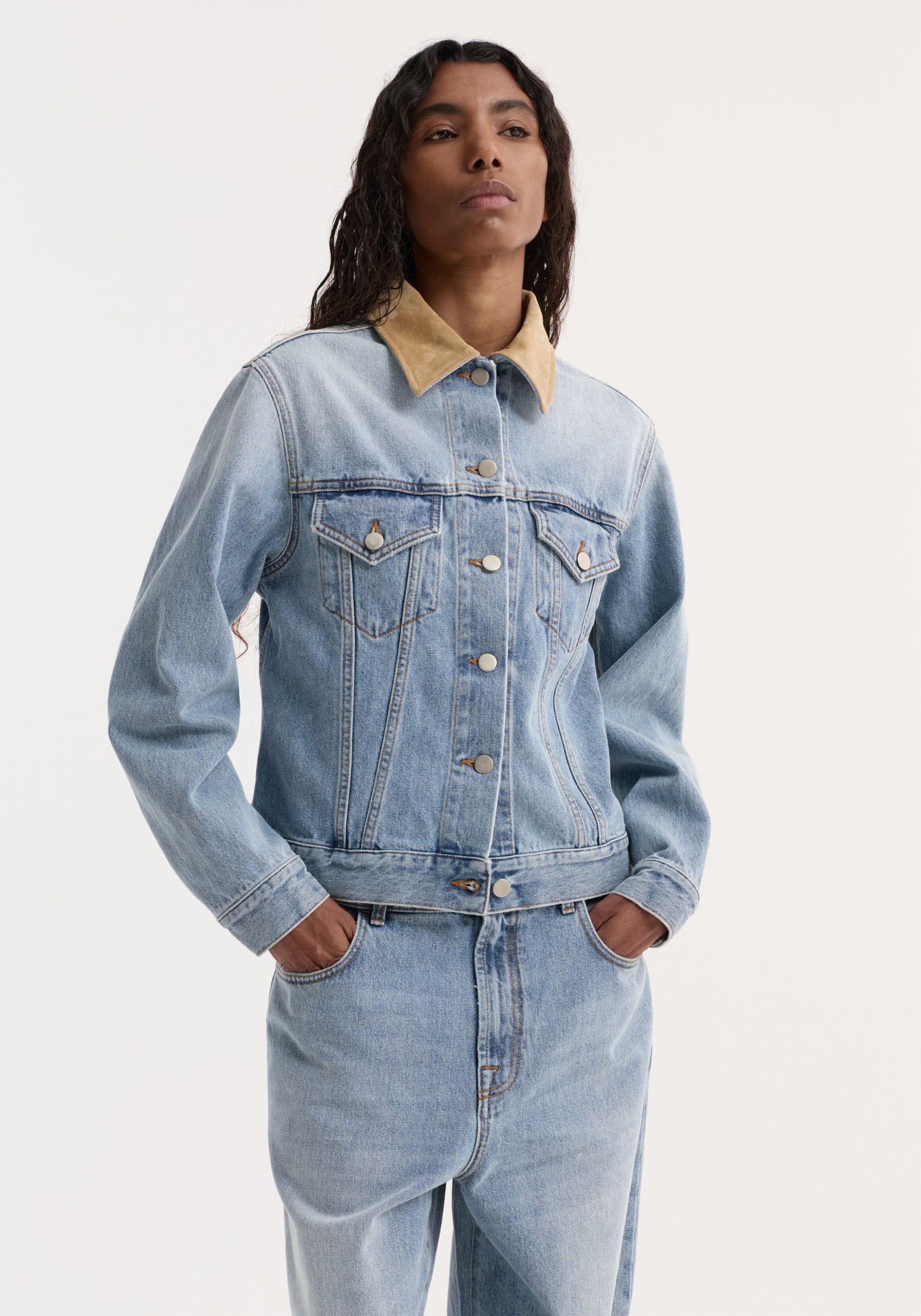 Woman wearing a Suede collar fitted denim jacket | classic blue in light blue denim with a contrasting tan suede collar, styled with matching denim jeans.