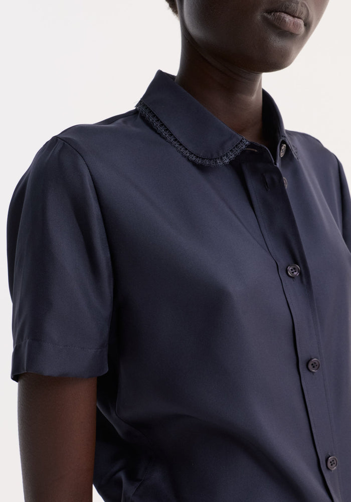 Embroidered silk fitted shirt | night: A close-up of a fitted, short-sleeve navy shirt with a scalloped-trim collar and delicate embroidery, made from 100% silk.