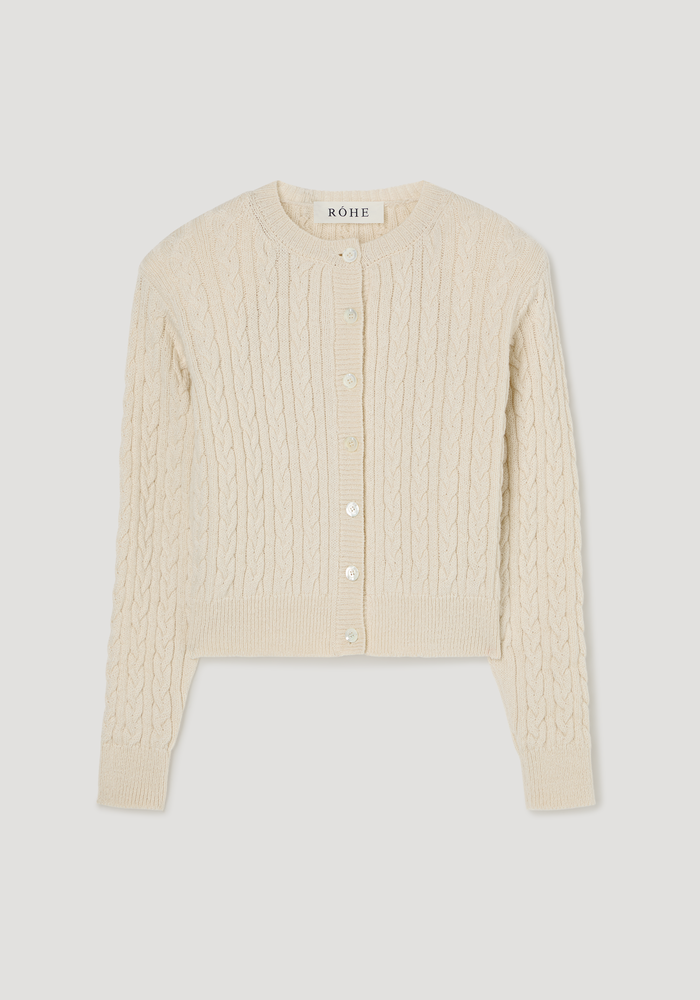 Fine merino cable cardigan | cream, featuring a round neckline, long sleeves, pearl-like buttons, subtle shoulder pads, and a slightly cropped, cable-knit design.