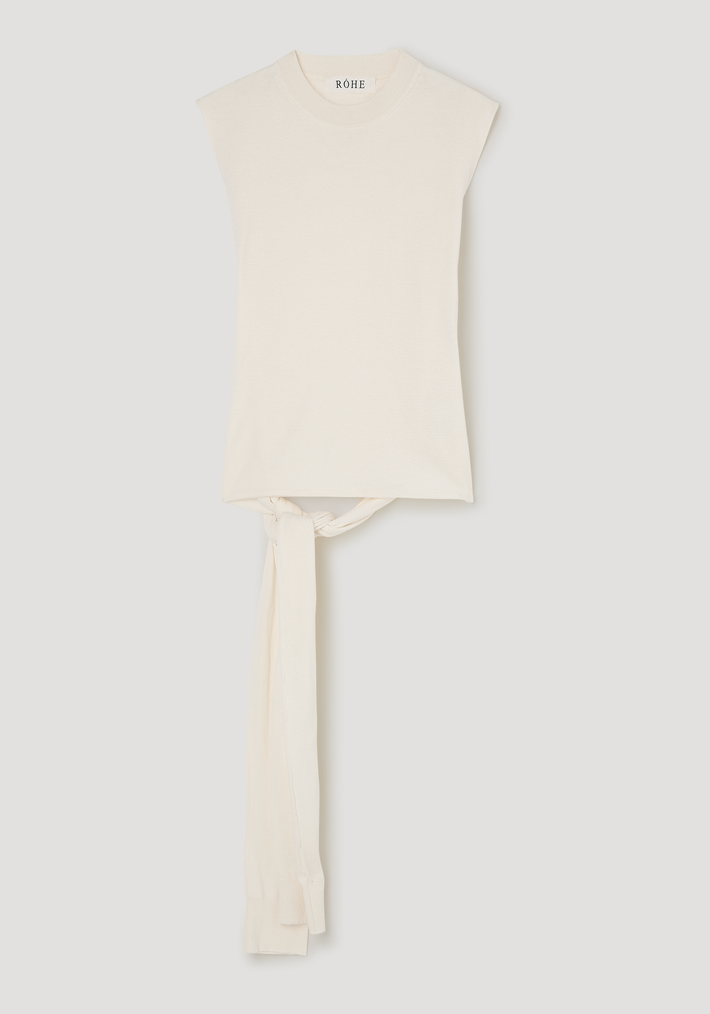 Open back knitted wrap top with a sleeveless, cream design, crew neckline, and long sash-like ties at the waist for added definition and style.