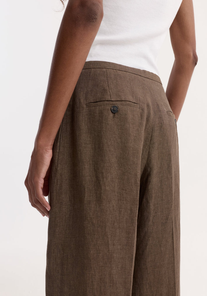 Person wearing Relaxed drawstring trousers in brown melange, featuring wide-leg design, back welt pockets, and drawstring waistband, showcasing a comfortable and breathable linen fabric.