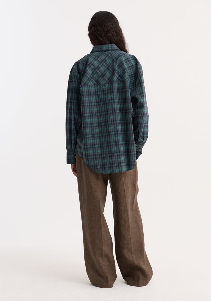 Person wearing Relaxed drawstring trousers in brown melange, featuring a wide leg and drawstring waistband, paired with a green-and-navy plaid shirt.