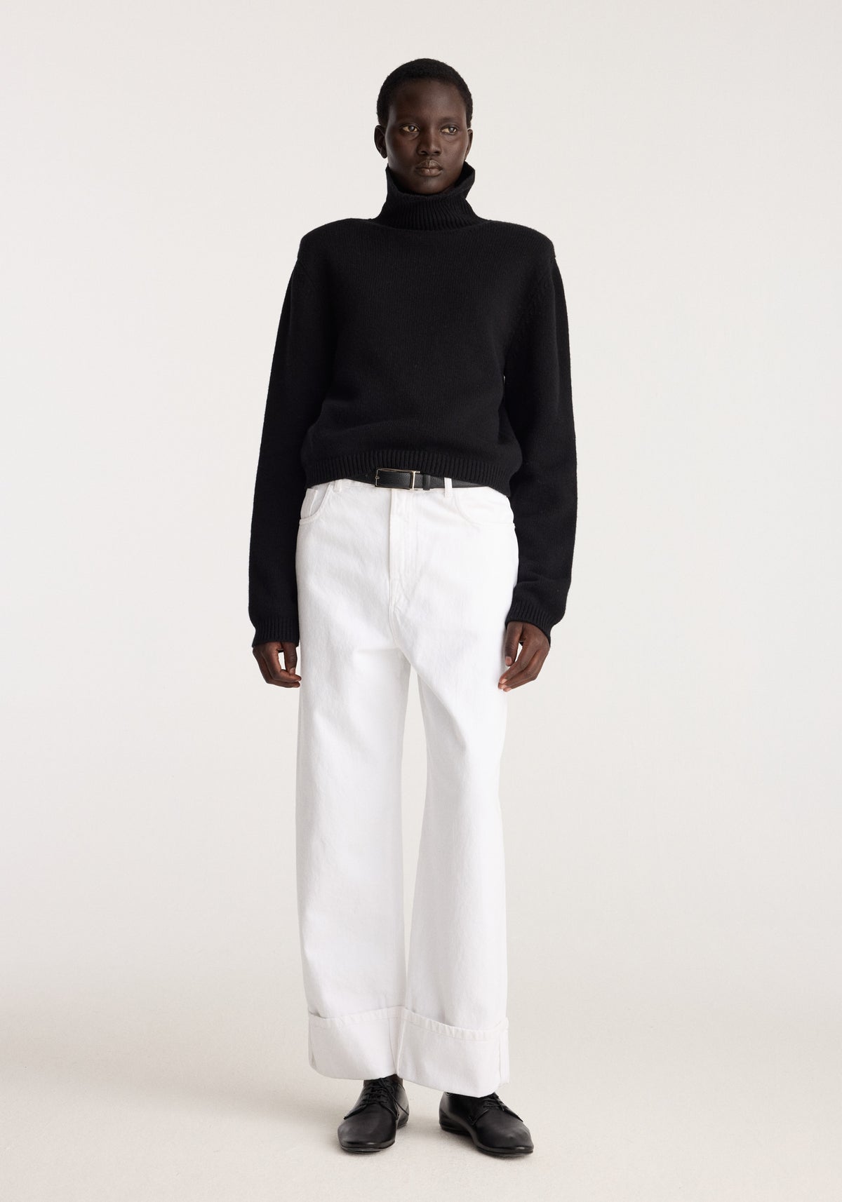 Baggy fit turn-up denim | optic white worn with a black turtleneck sweater and black shoes, showing the relaxed wide-leg silhouette and turned-up hems on a model
