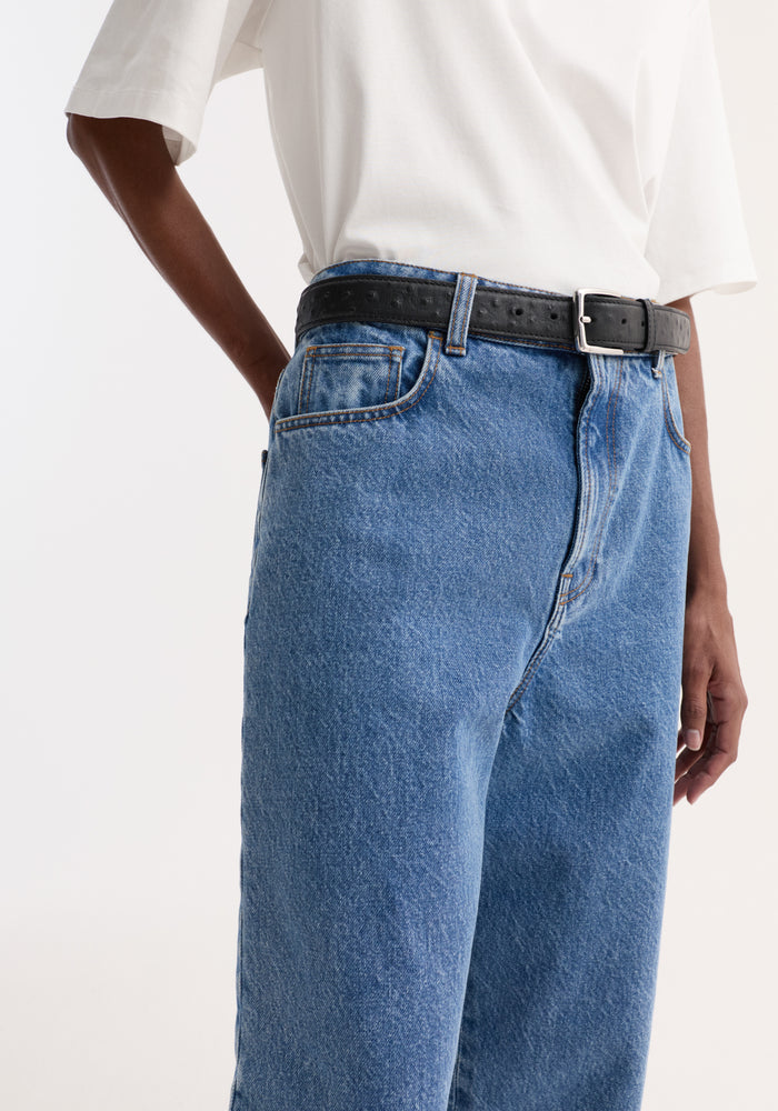 Turn-up baggy denim | heritage blue shown with a low-rise, wide-leg fit, cinched by a black leather belt, and tucked-in plain white T-shirt.