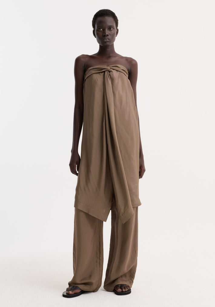 Model in Sarong top | brown mini check, featuring a knotted bust, front slit, and inner bustier, paired with matching wide-leg trousers and black sandals.