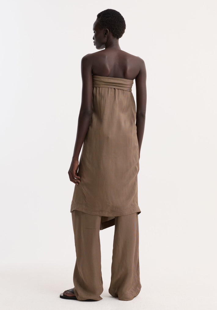 Person wearing Sarong top with front knot and slit, over matching trousers, viewed from behind. Black slide sandals complete the minimalist look.