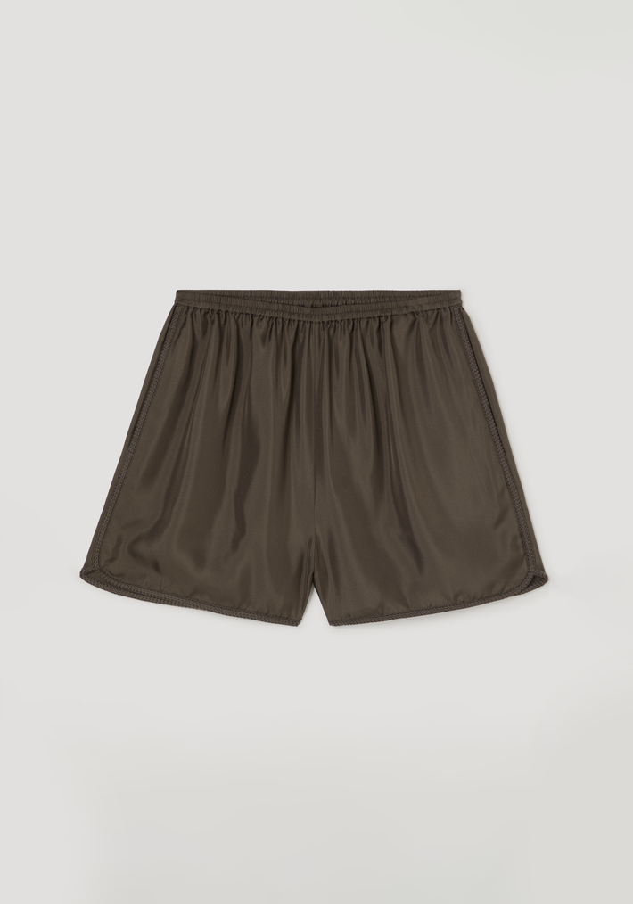 Taped silk shorts | earth featuring lightweight fluid design, elasticated waistband, and intricate embroidered hem detailing, laid flat to showcase pleating and tape accents.