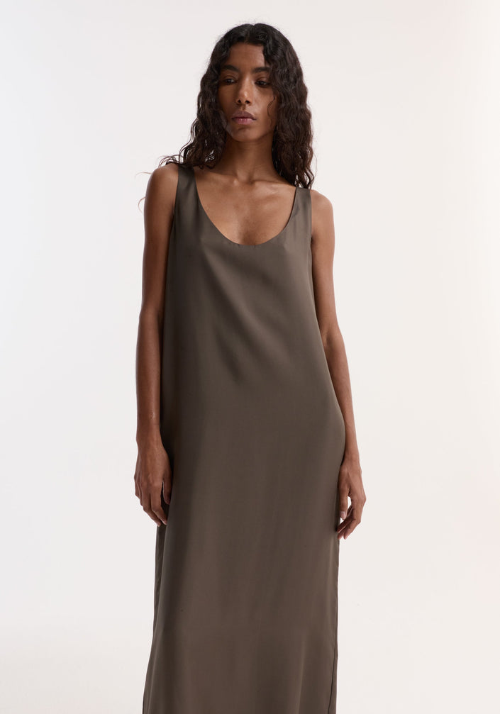 Silk scoop-neck dress | earth: Model in a sleeveless, ankle-length silk dress with a deep scoop neckline, relaxed fit, paired with black heeled sandals.