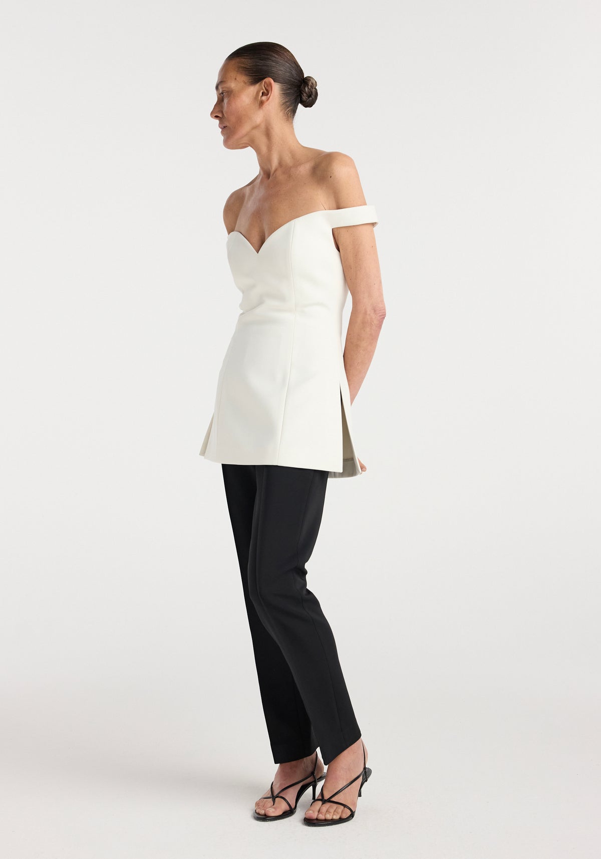 Off shoulder top | cream modeled with a sweetheart neckline and fitted silhouette styled with black trousers and strappy sandals