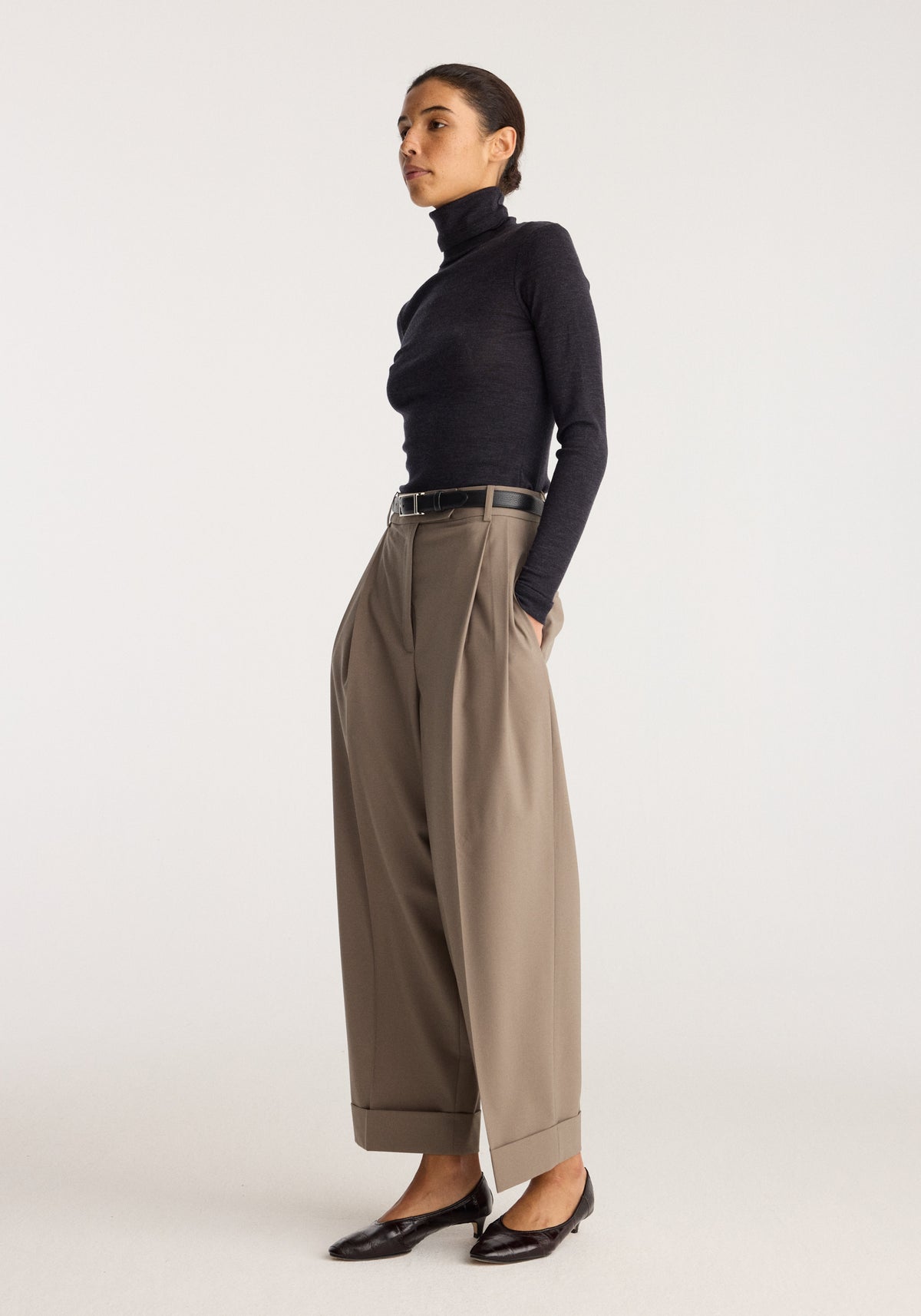 Fine merino turtleneck | anthracite melange worn with wide leg trousers and loafers on a model in a studio setting