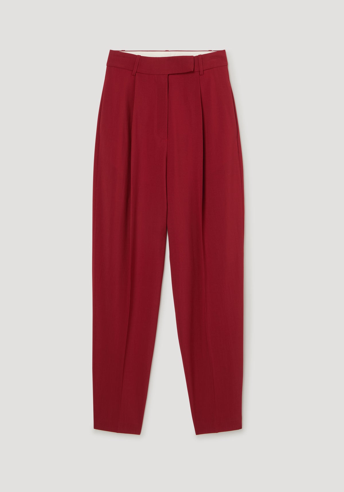 Daria - Single pleat tapered trousers | carmine shown in deep red with a high waist and tailored tapered legs on a light background