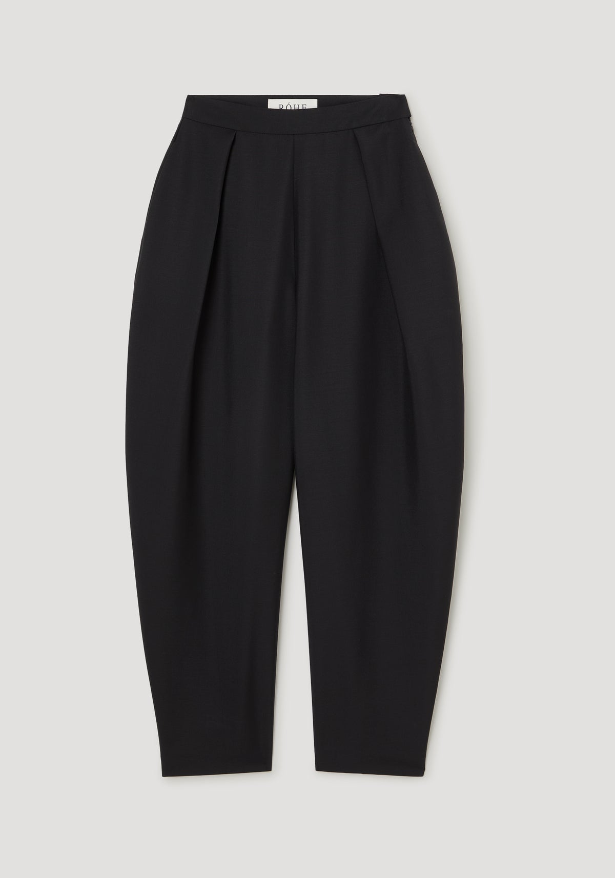 Puck - Sculptural tailored trousers | black shown front-facing with a high waist pleated design and sculptural tapered legs on a light background