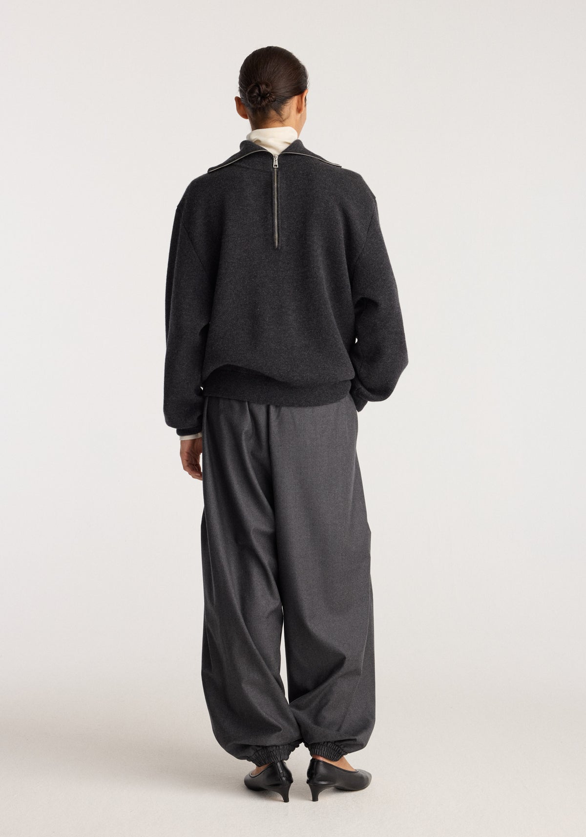 Balloon track pants | dark grey melange shown from the back on a model with a loose fit and gathered ankle cuffs