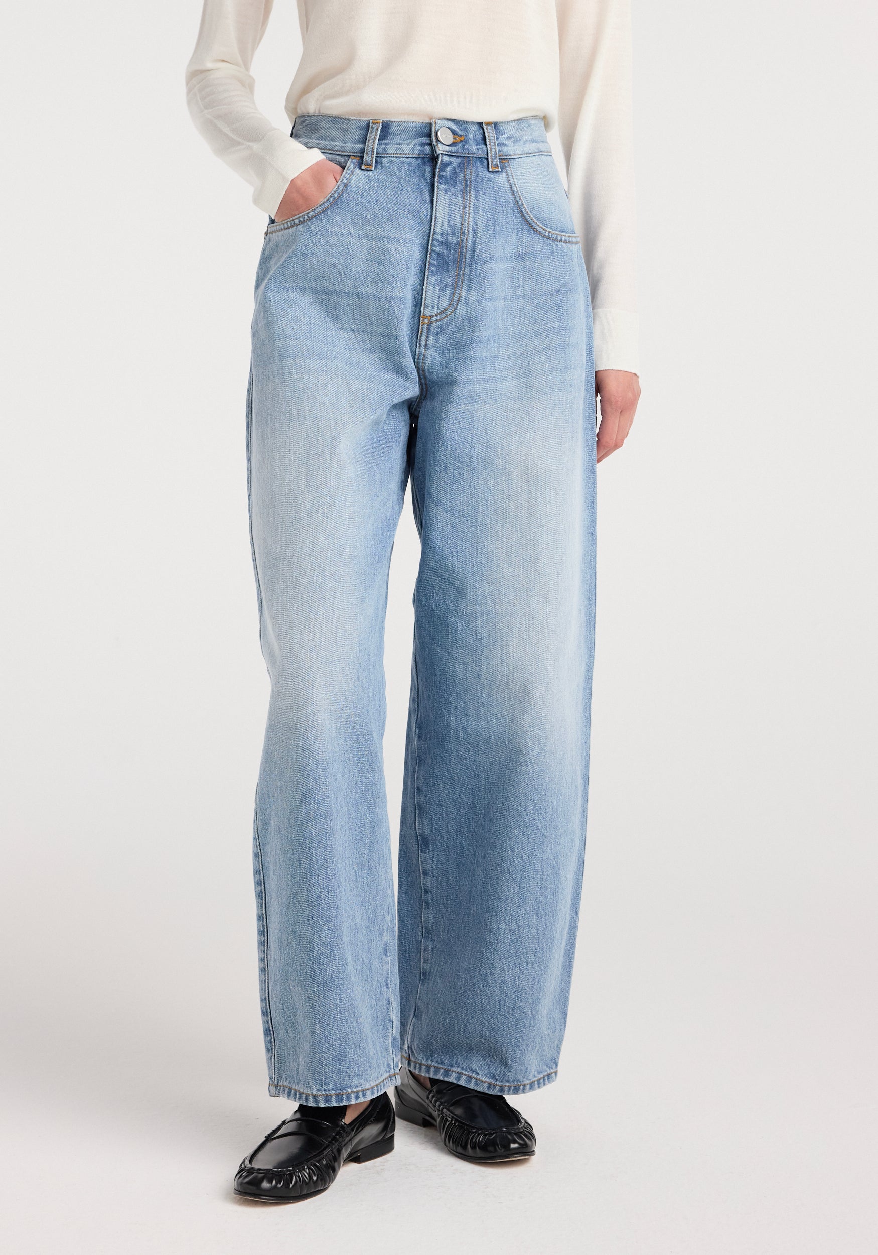 Model wearing Berber - Barrel leg denim | classic blue with a high waist and relaxed wide legs, paired with black flat shoes and a long-sleeve white top.