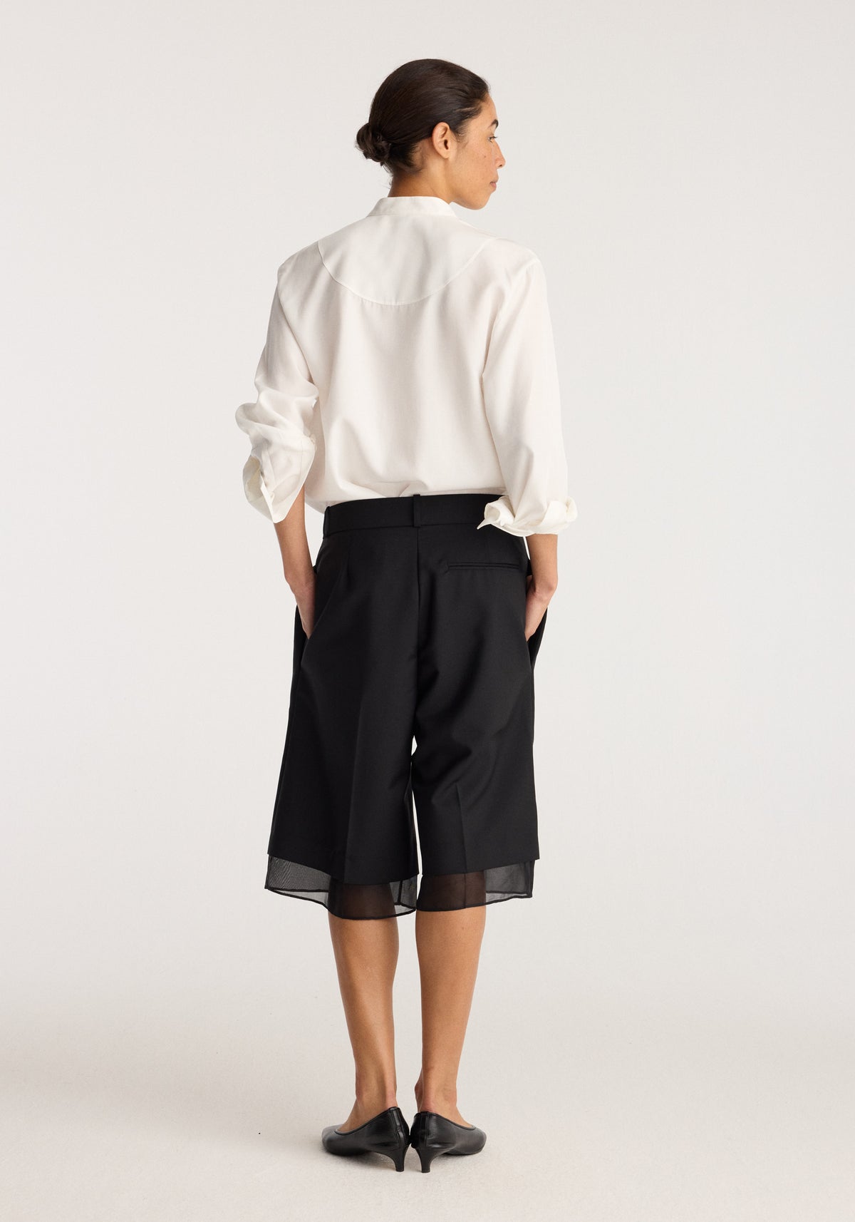 Organza lined shorts | black shown from the back on a model wearing a white blouse with sheer panels at the hem