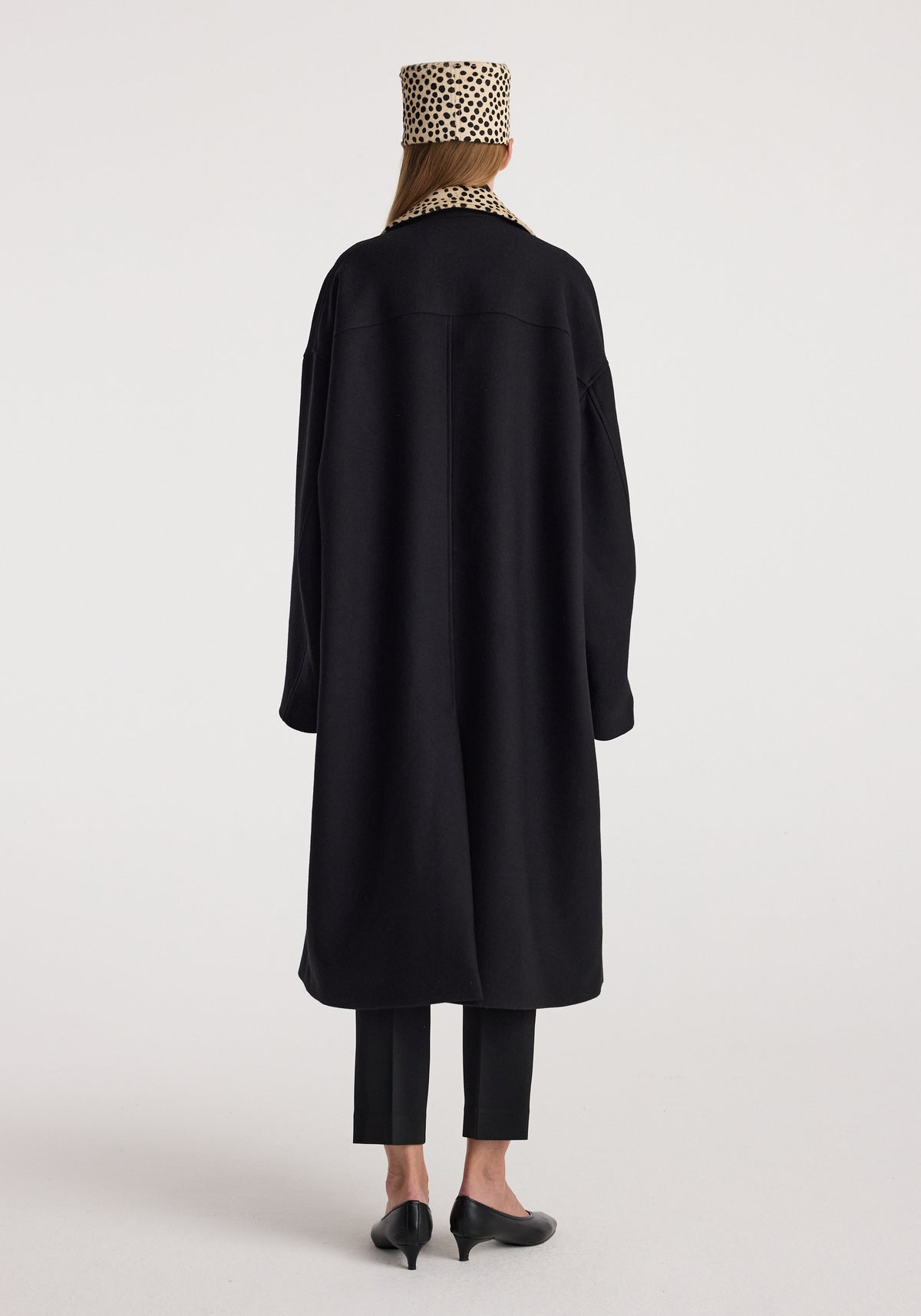 Cheetah collar wool coat | black shown from the back on a model, featuring a long relaxed silhouette, long sleeves, and a sleek black finish