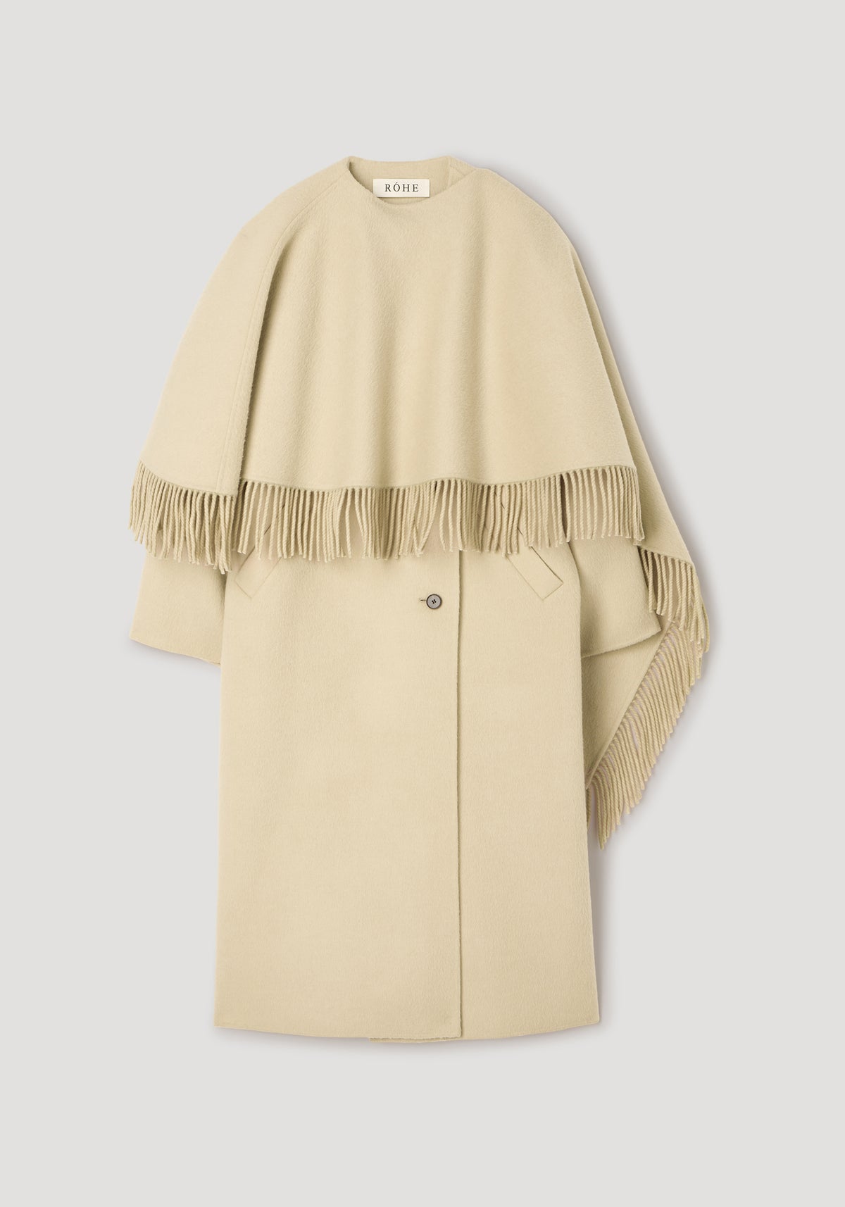 Double-faced fringe coat | butter displayed flat, featuring a soft beige color with a fringed cape overlay and a classic button closure on the main coat.