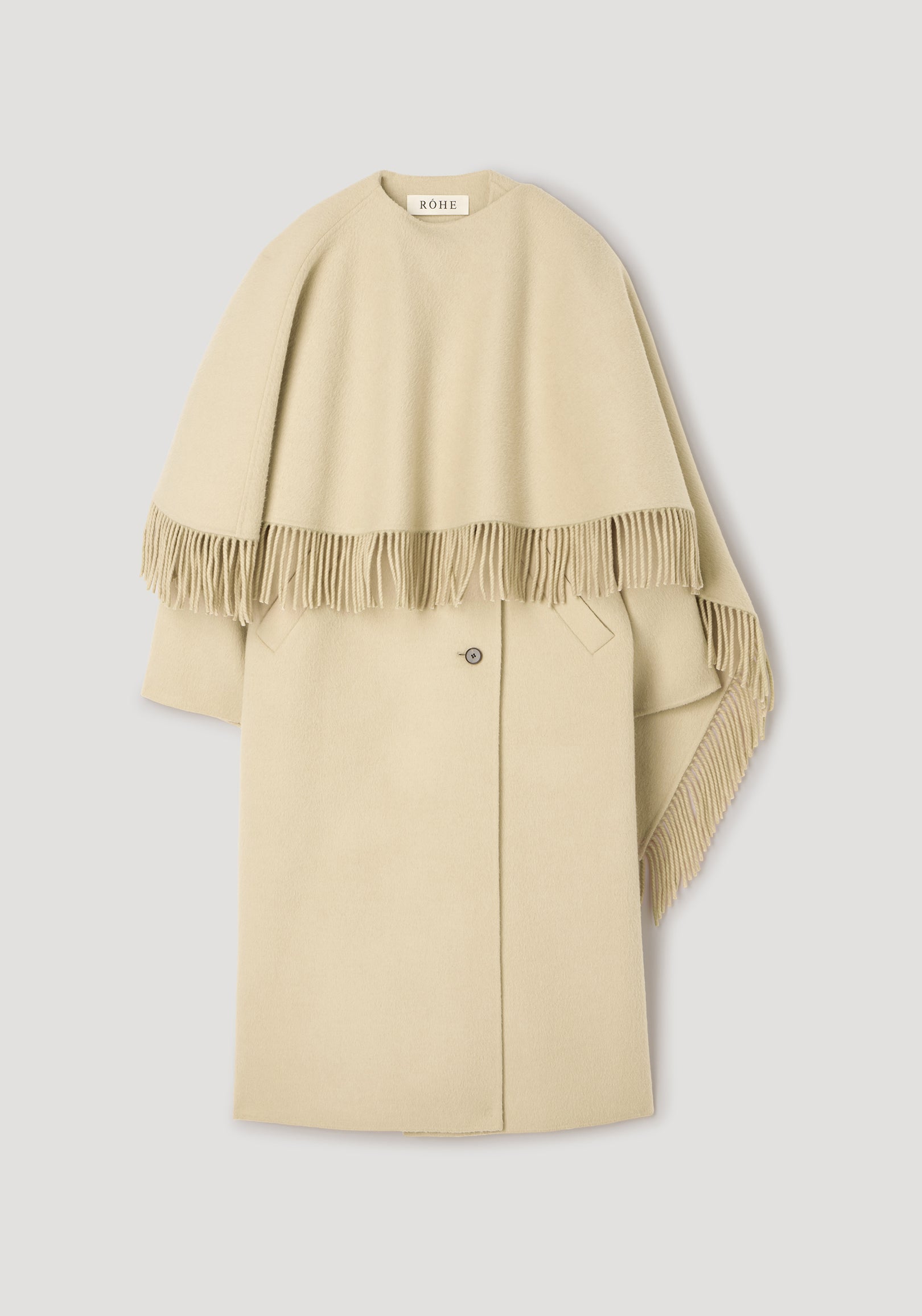 Double-faced fringe coat | butter displayed flat, featuring a soft beige color with a fringed cape overlay and a classic button closure on the main coat.