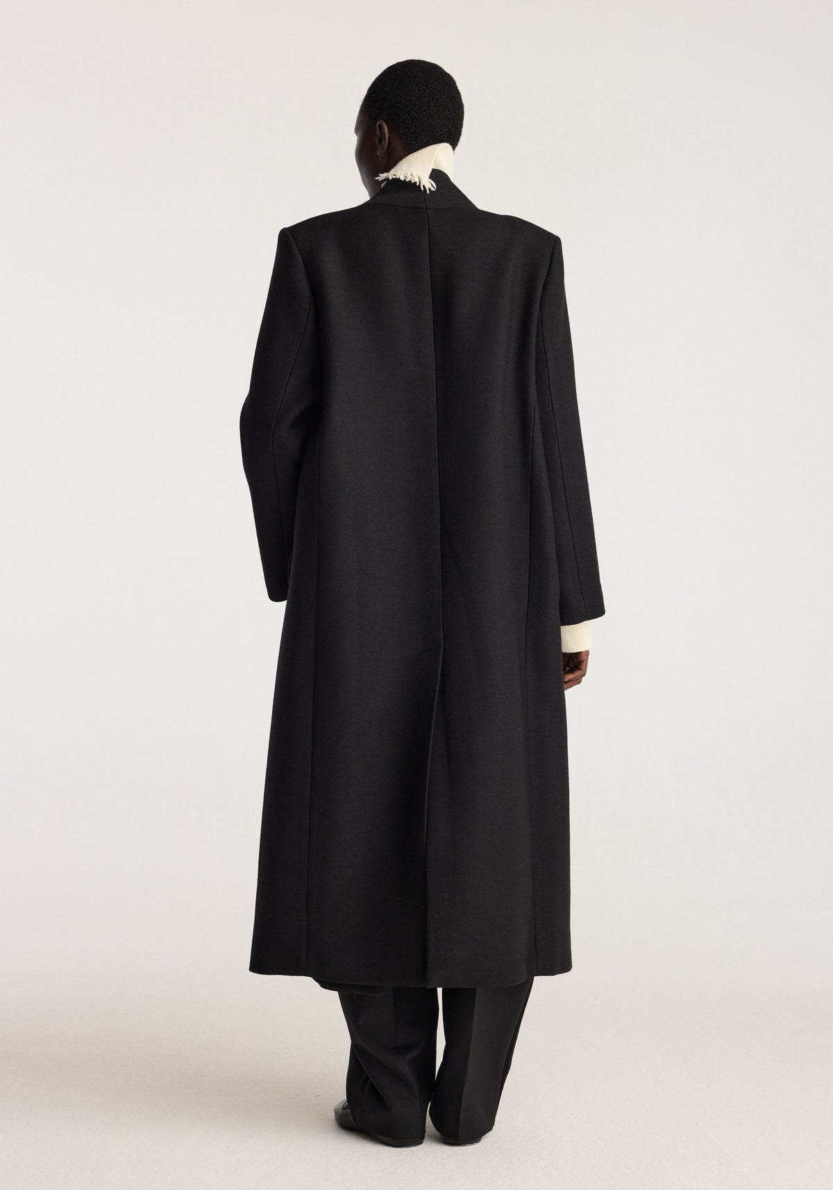 Pankou closure wool coat | black shown from the back with a long straight silhouette, high collar, long sleeves, and concealed back styling