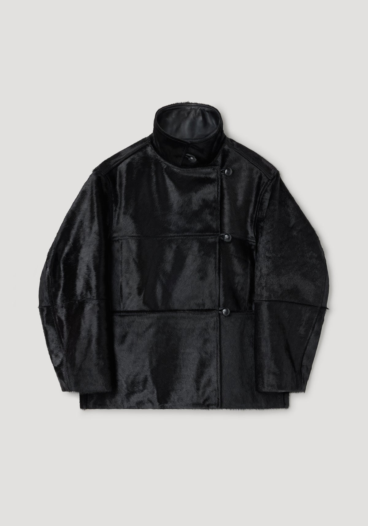 Black ponyhair jacket | black with a high collar and button closure, featuring a smooth, shiny texture and a structured, modern design.