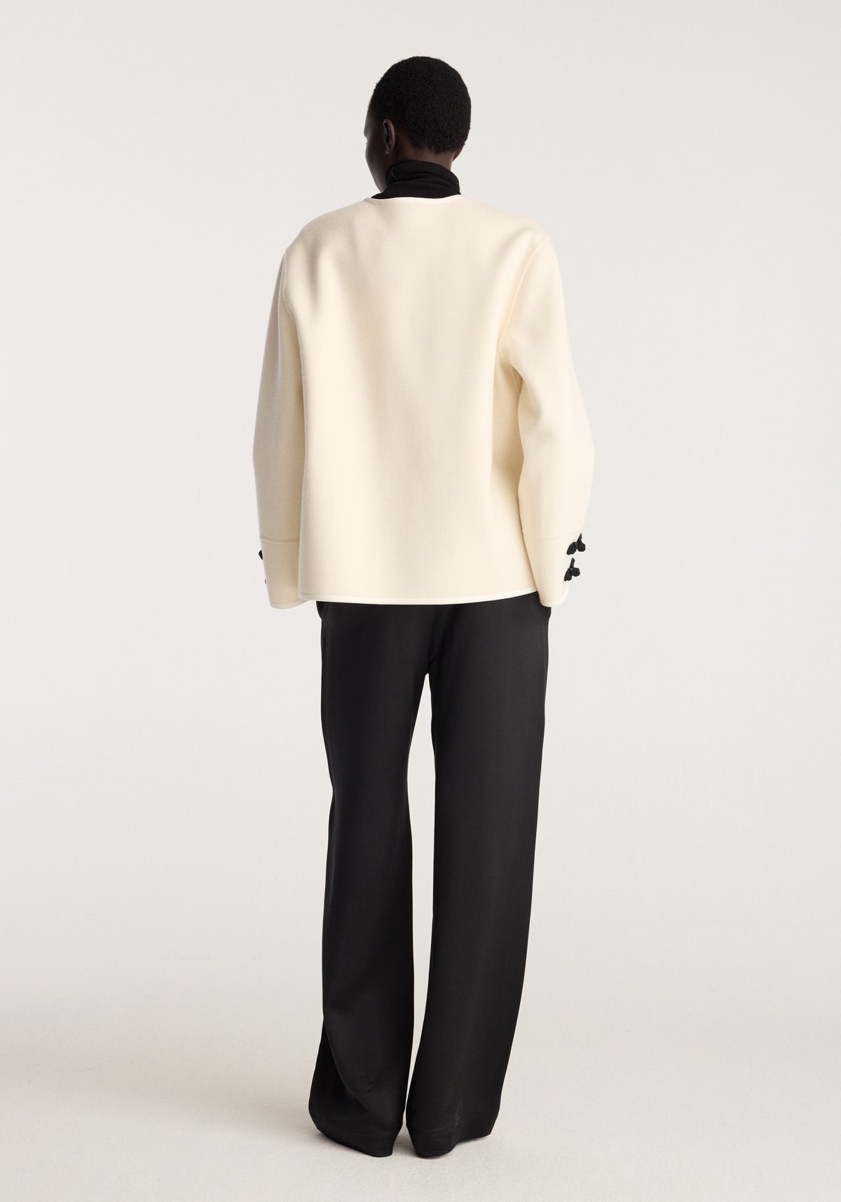 Double-faced pankou jacket | off white shown from the back on a model with long sleeves, paired with black trousers against a neutral studio background