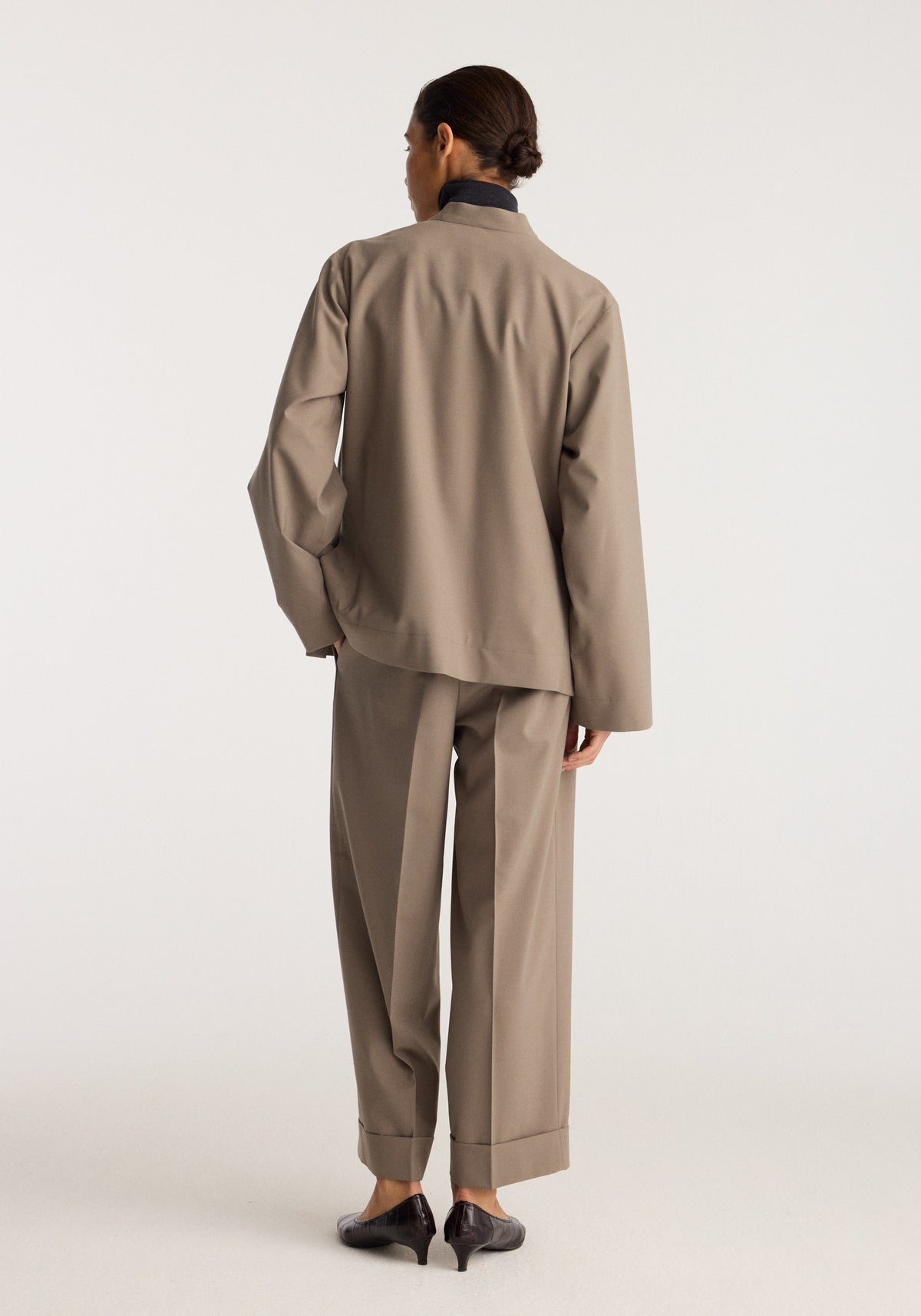 Pankou closure jacket | taupe shown from the back on a model with a relaxed fit long sleeves stand collar and matching tailored trousers