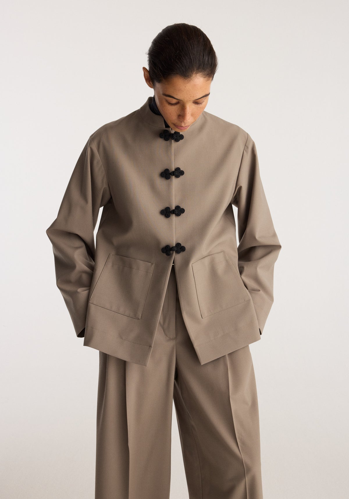 Pankou closure jacket | taupe worn by a model featuring traditional pankou closures patch pockets and a relaxed tailored fit with matching trousers