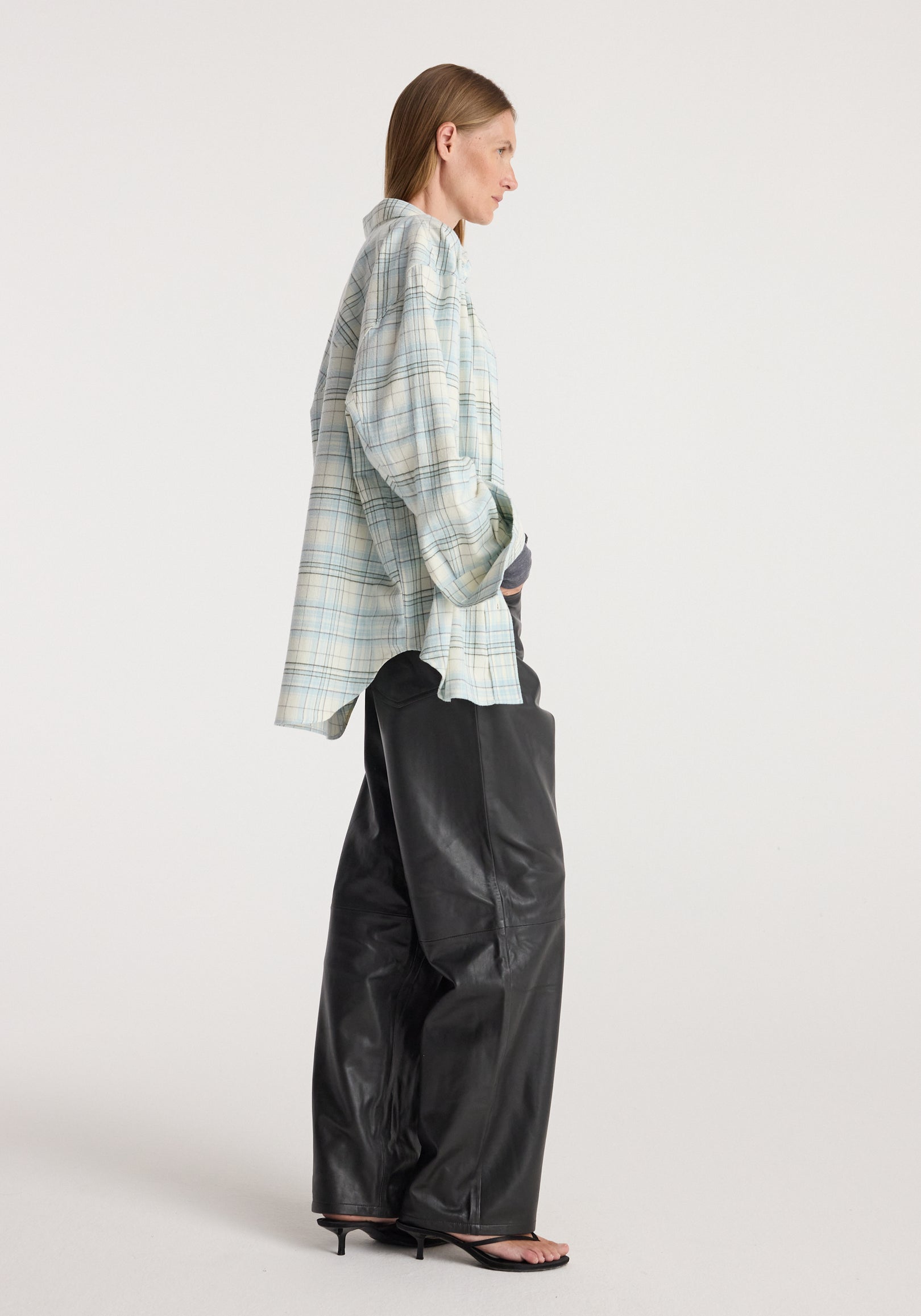 Flannel check overshirt | sea green check, shown from the side on a model styled with black trousers and sandals against a neutral studio background