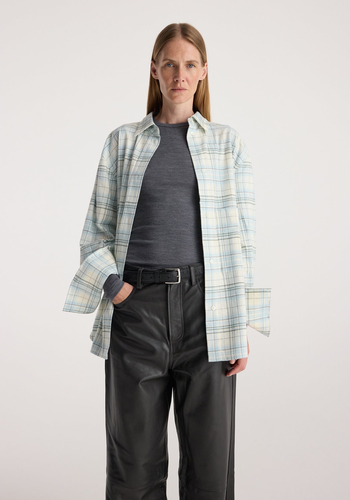 Flannel check overshirt | sea green check worn open over a dark top with black leather trousers by a model against a neutral background