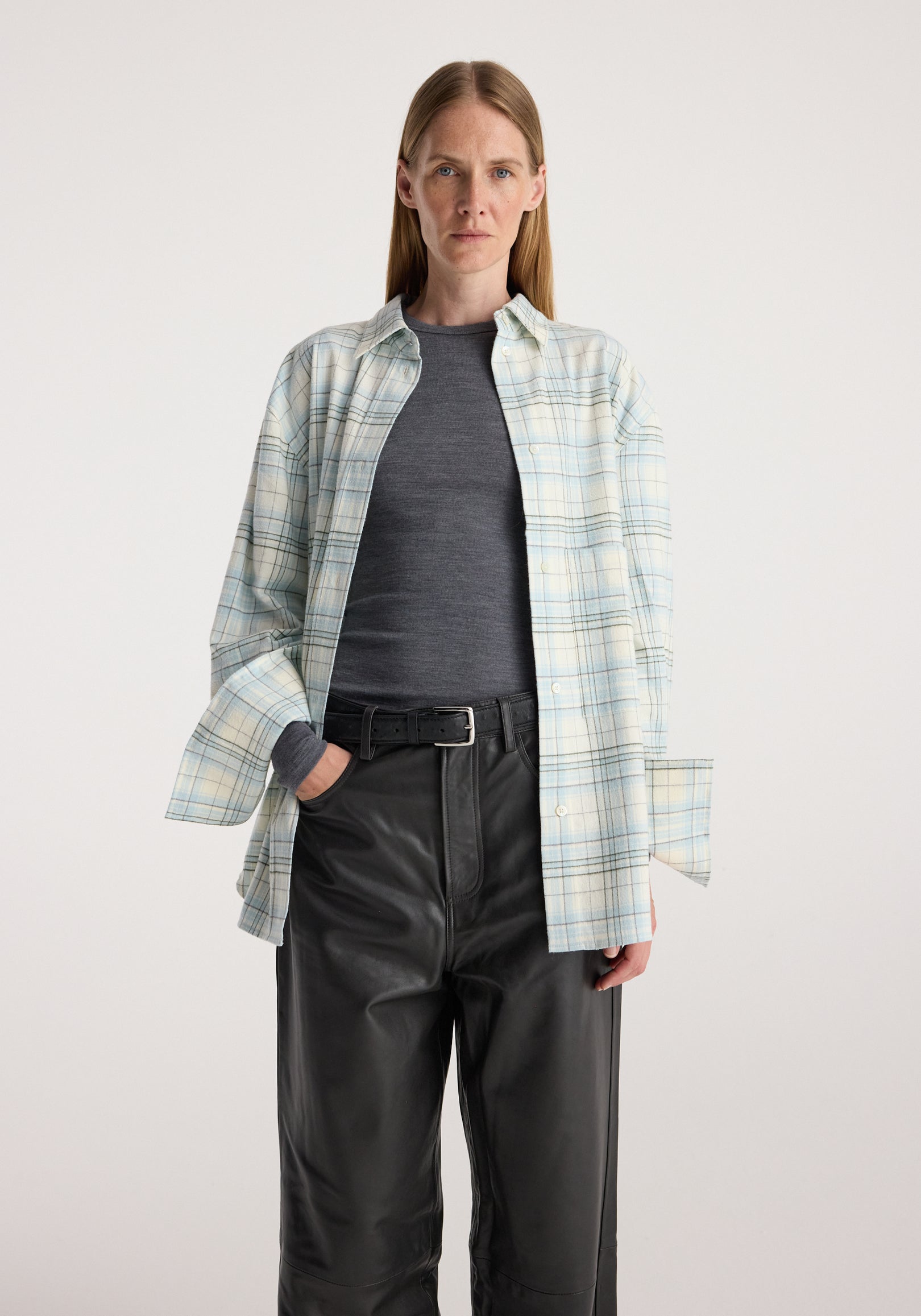 Flannel check overshirt | sea green check worn open over a dark top with black leather trousers by a model against a neutral background